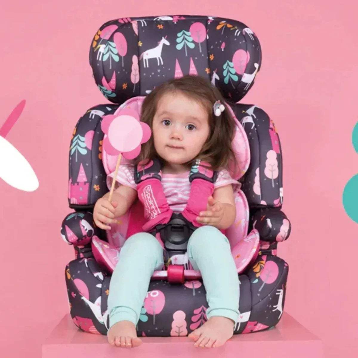 Charcoal car seat with pink heart print, child seated with harness fastened