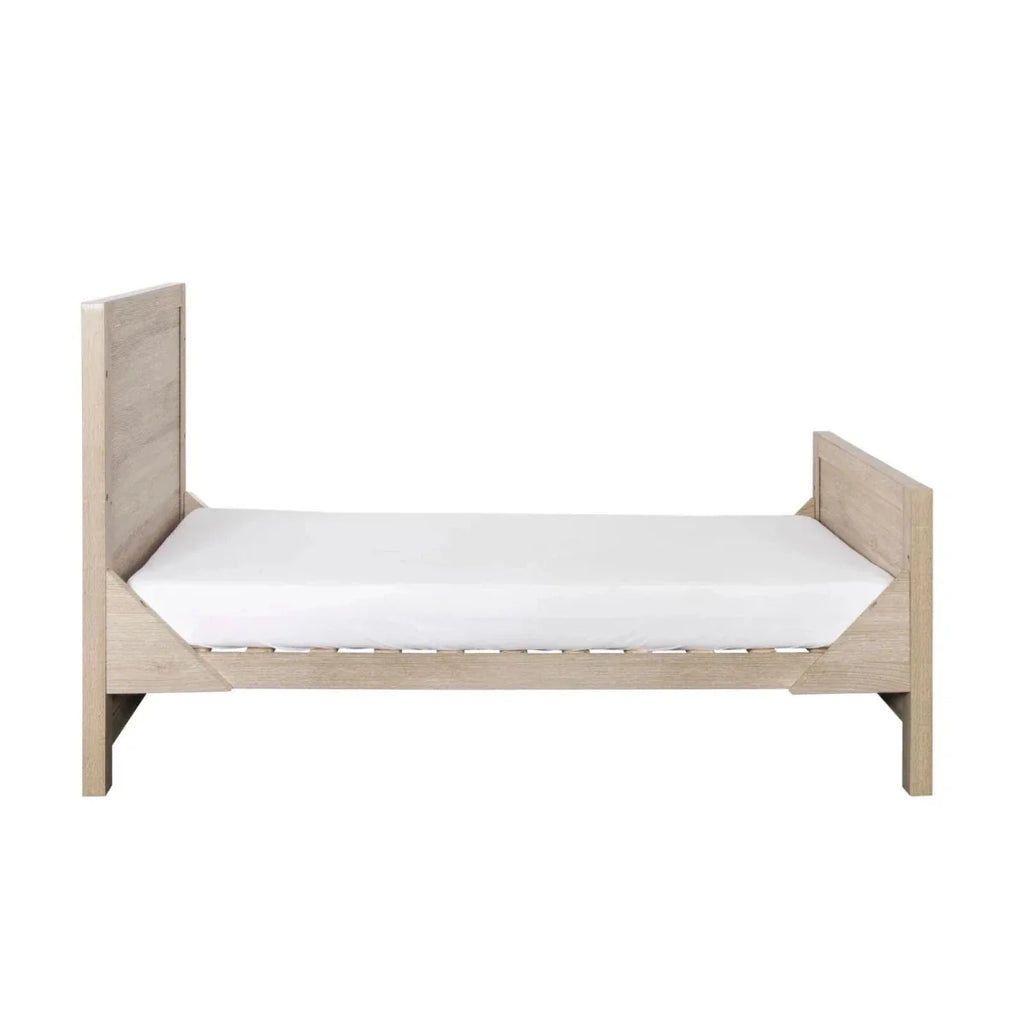 Light oak low-profile bed with white mattress, side rails