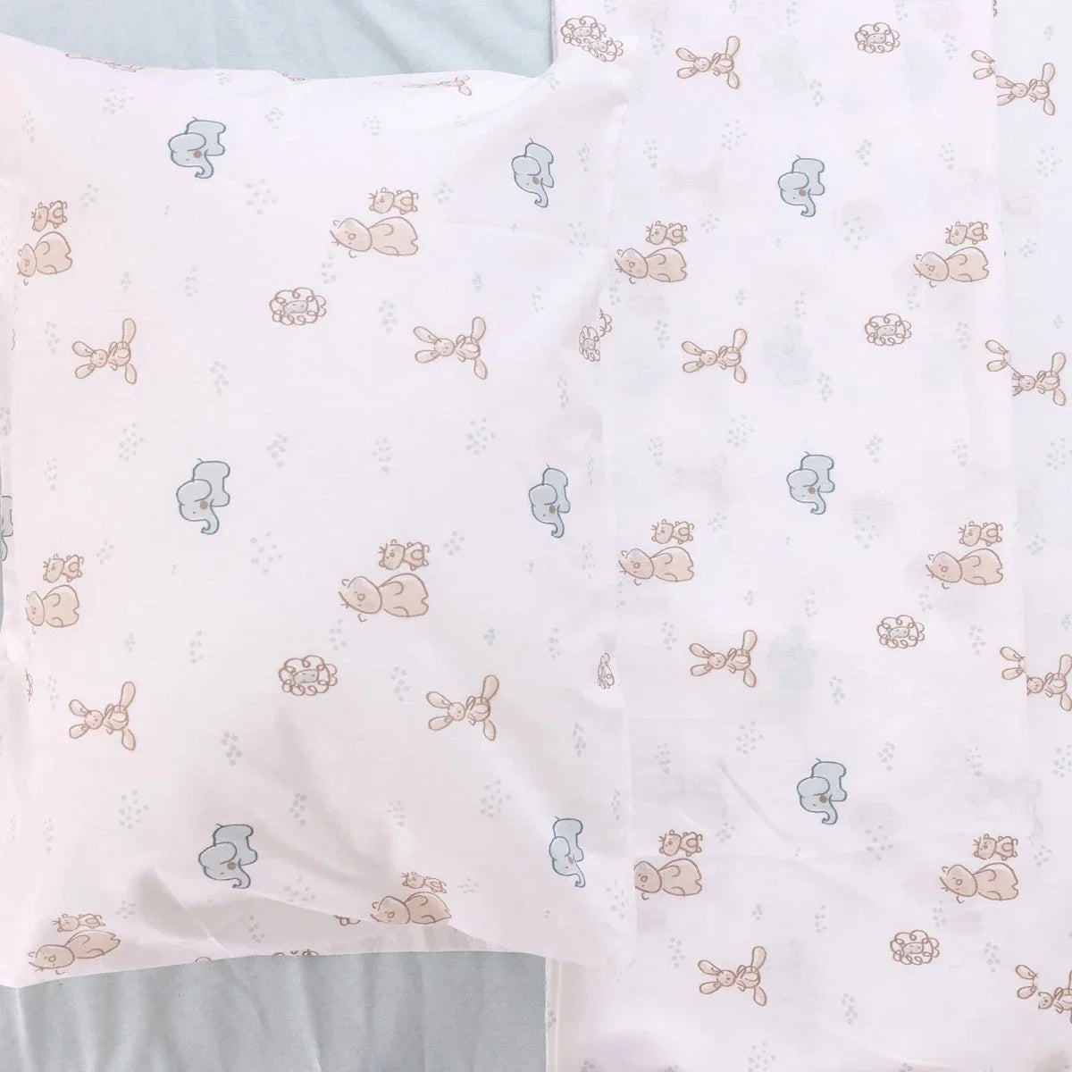 Folded duvet cover with repeating pale blue and beige animal print pattern