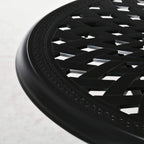Close-up of black round tabletop rim with decorative embossed pattern