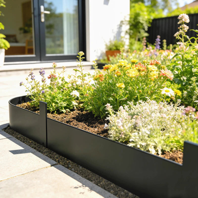 Black metal garden fence edging with straight line and small pickets.