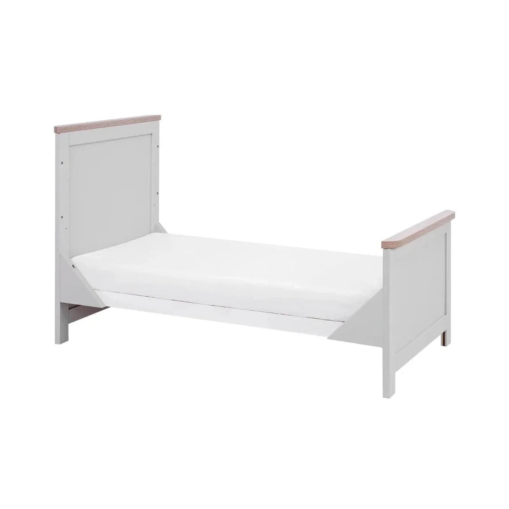 Low-profile sofa bed cot conversion with white frame, vertical ends, and oak-toned rails