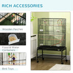 Black bird cage with wooden perches, food and water containers, and bird toys