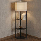 Black floor lamp with lit fabric shade and three open shelves