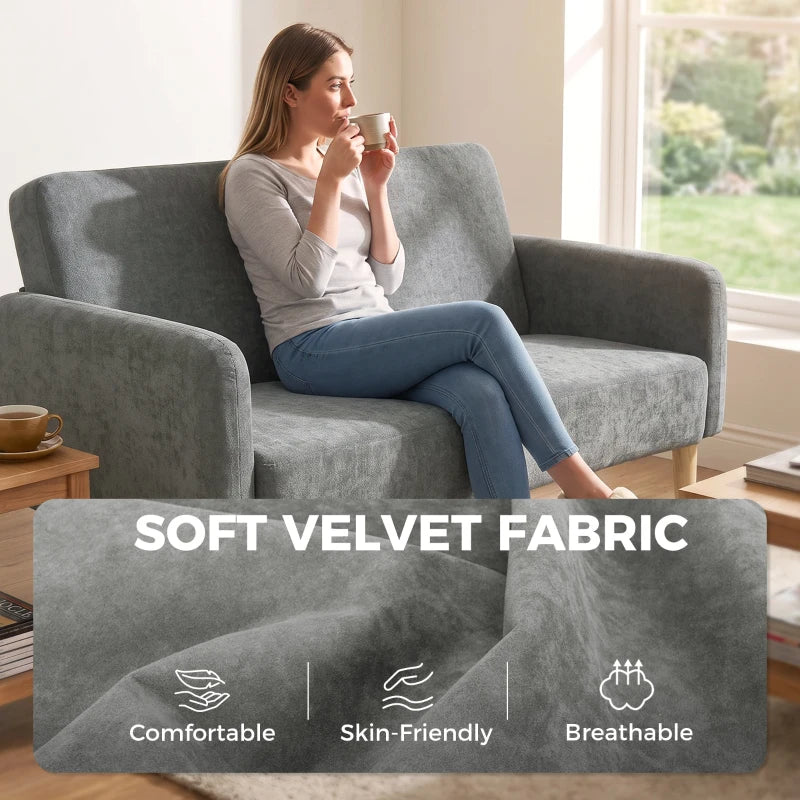 Grey velvet sofa with plush armrests and tall backrest in soft upholstery