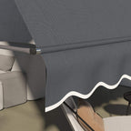 Dark grey retractable awning corner detail with scalloped valance over patio seating