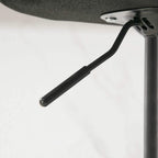 Black metal footrest support bar from a green retro bar stool