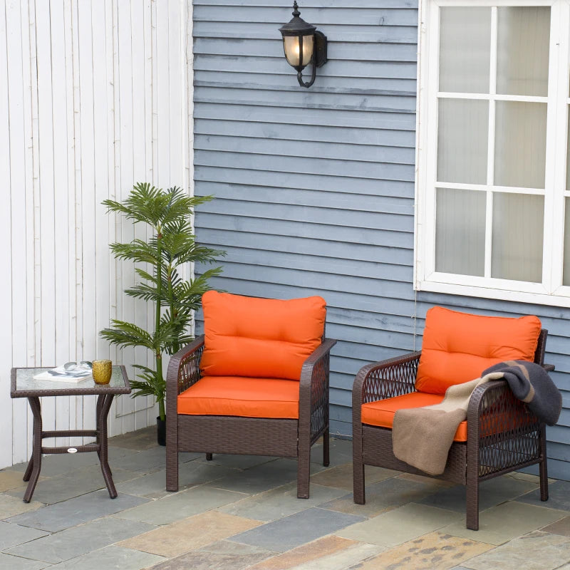 Two outdoor rattan bistro armchairs with orange cushions