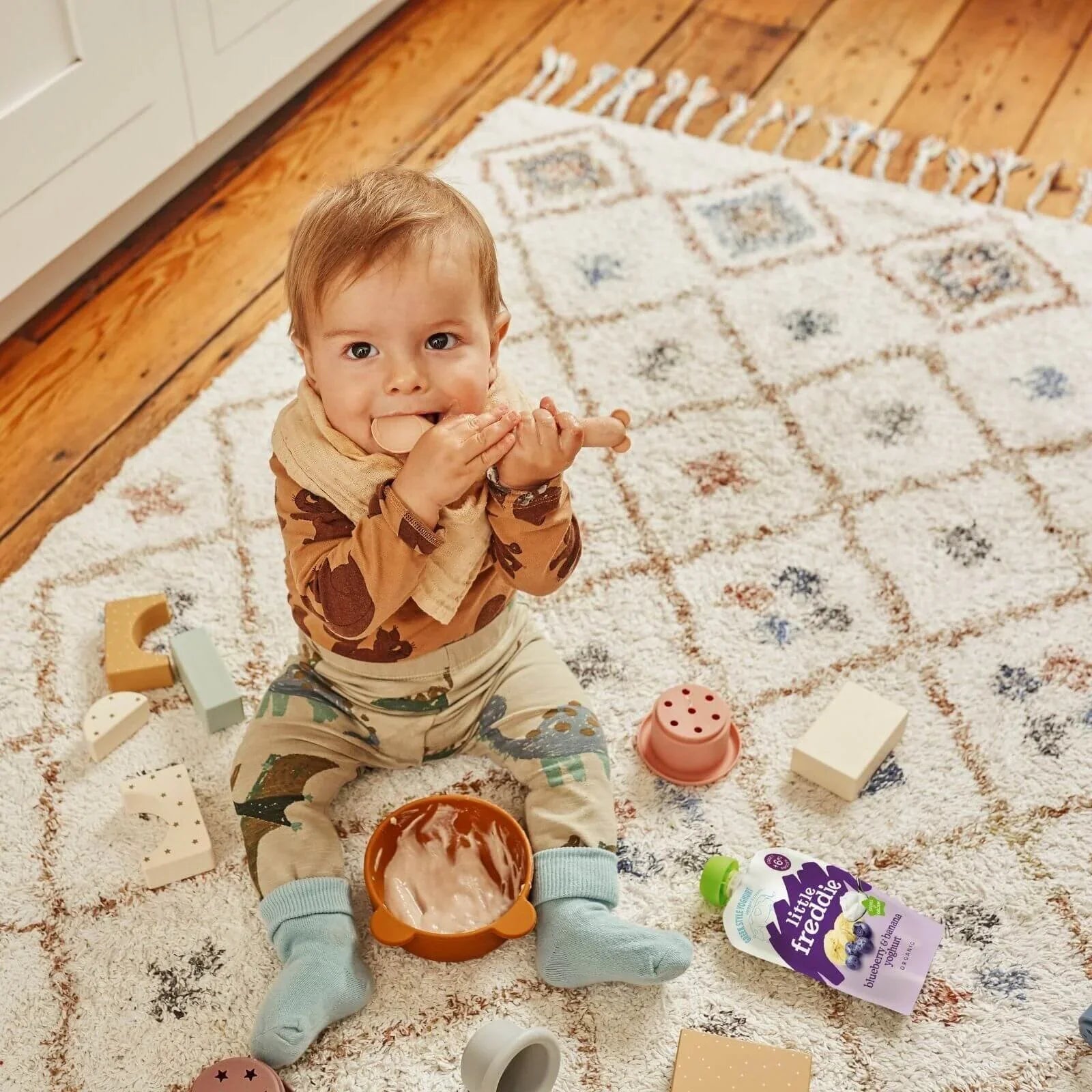Little Freddie blueberry & banana yogurt pouch on play mat with green spout
