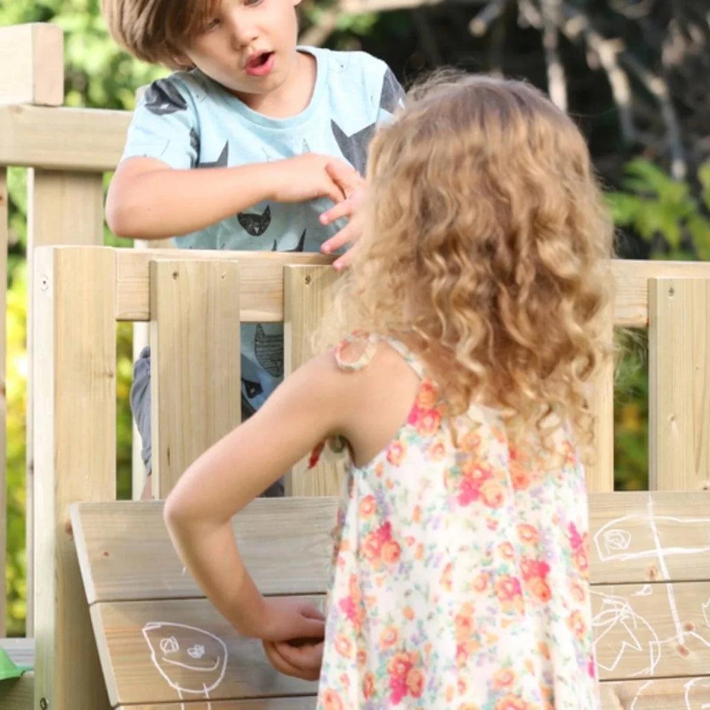 Wooden playset ladder and railings with children climbing, near slide access