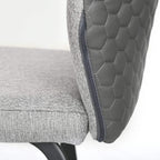Close-up of light grey upholstered back with quilted pattern and edge piping