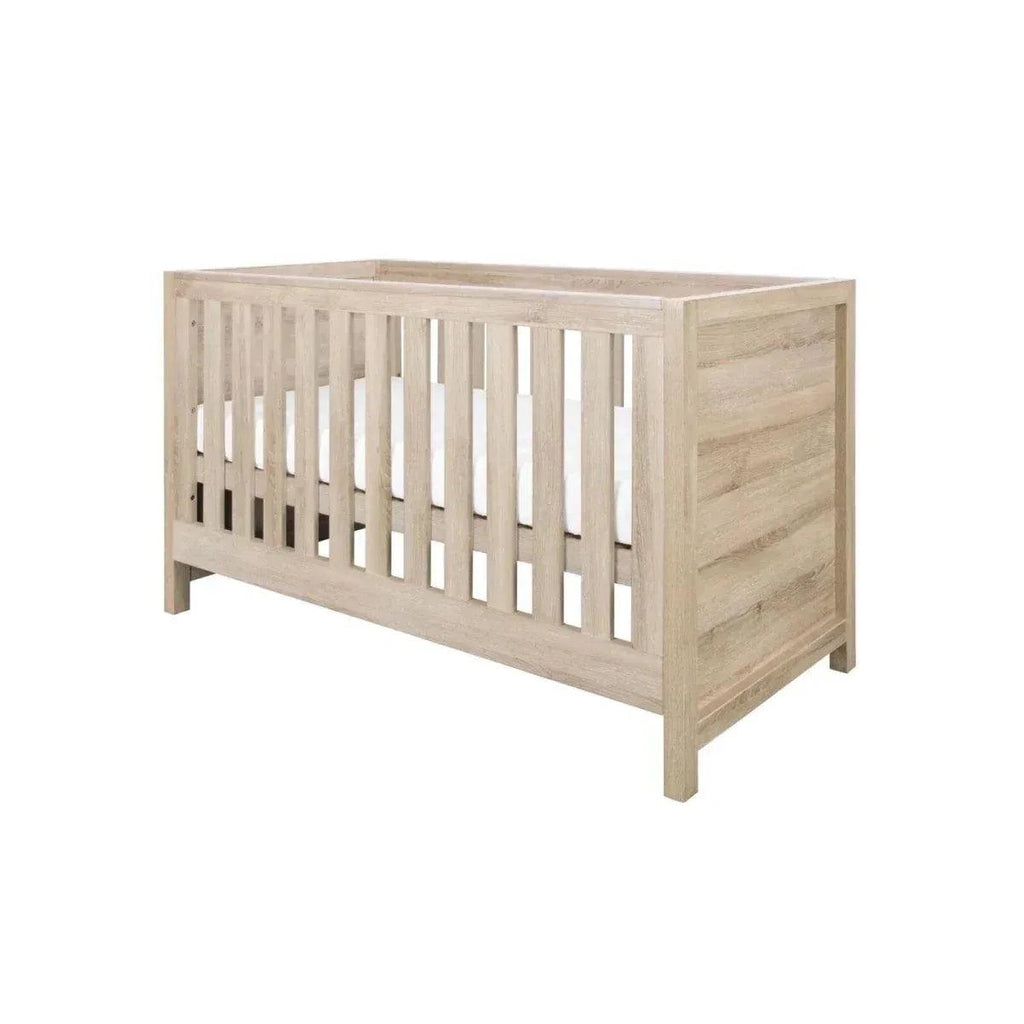 Oak cot bed with slatted rails and sturdy side panels, light wood finish