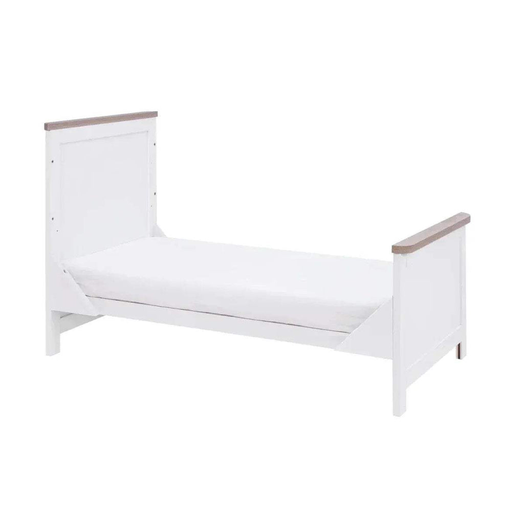 White sofa-style bed with oak armrests and a low slatted side