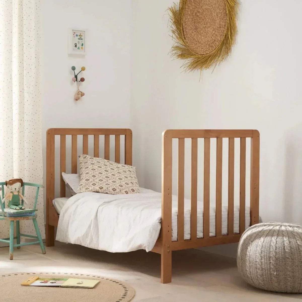 Honey oak toddler cot bed with vertical slat sides and white bedding