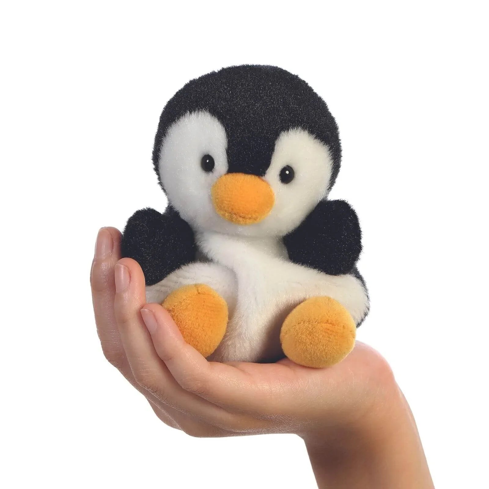 Black and white penguin plush toy held in a hand; orange beak and feet visible.