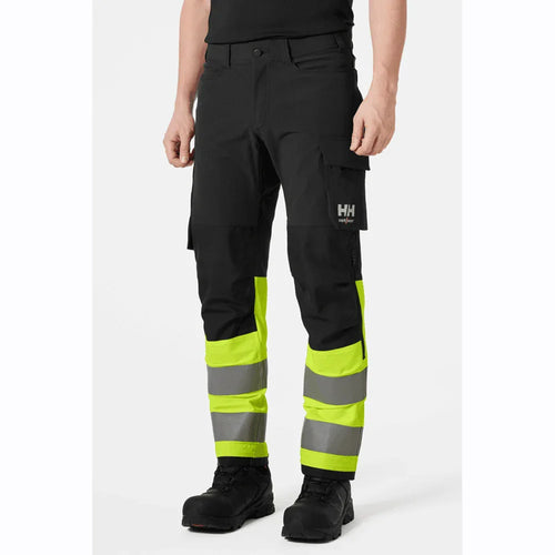 Hi-vis cargo pants in dark fabric with lime reflective bands and cargo pocket detail.