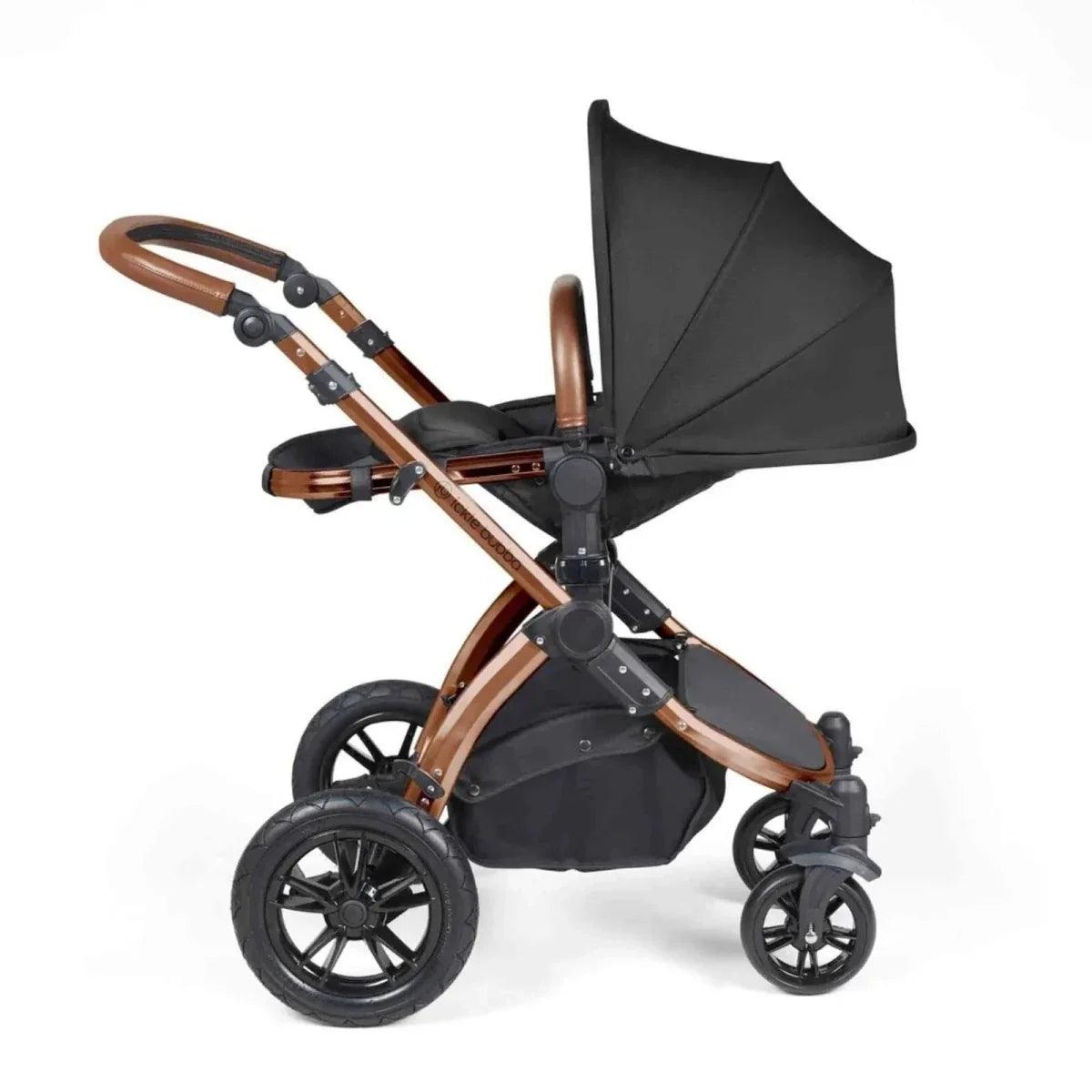 Black stroller with bronze handlebar, tan accents, and adjustable seat canopy