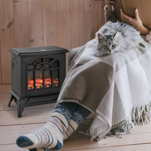 Black electric fireplace heater stove beside a couch and blanket, showing LED flame window.