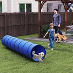 Blue dog agility tunnel with circular open ends, positioned in a backyard yard