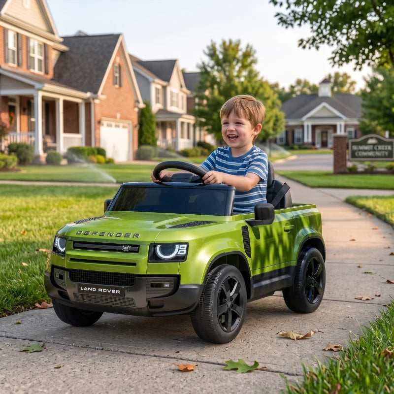 Green kids ride-on car with smiling child driving outdoors on a driveway
