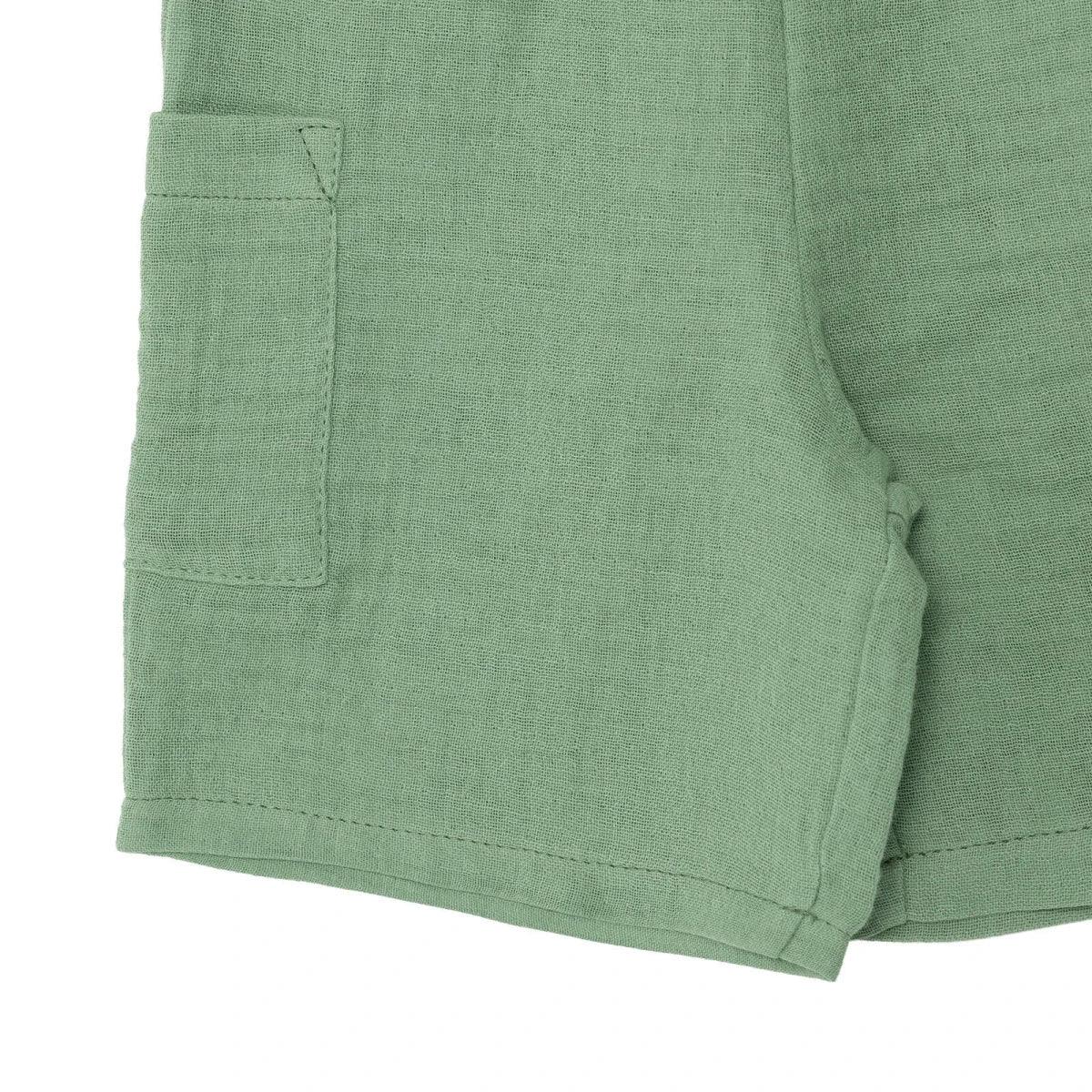 Green muslin baby shorts with patch pocket and stitched hem
