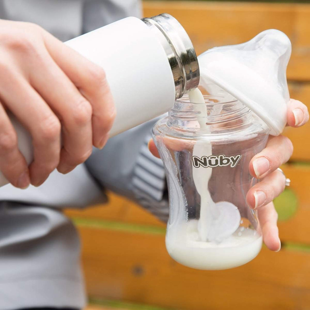 Nuby bottle with formula being poured into an infant feeding cup