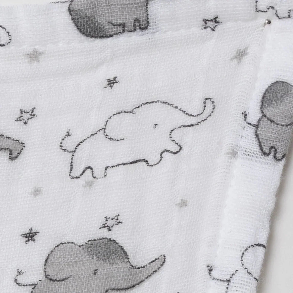 Close-up of white muslin fabric with stitched gray elephant outlines and stars