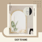 Beige arched wall mirror with grooved frame and wall hanging hooks