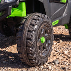 Treaded black tire with green center hub on a green and black ride-on UTV