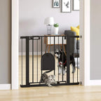 Black pet safety gate with cat flap door installed in a doorway, pets visible