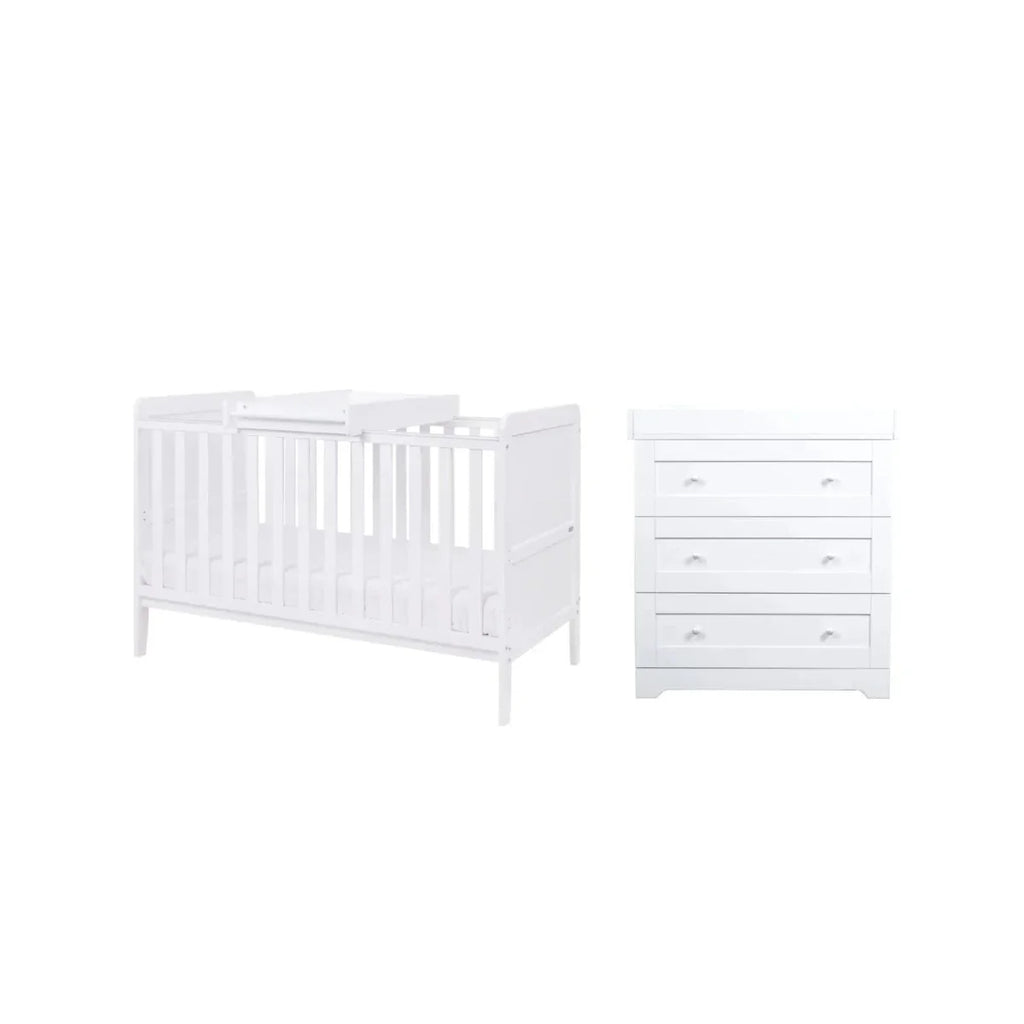 White cot bed with slatted sides and matching dresser with three drawer tiers