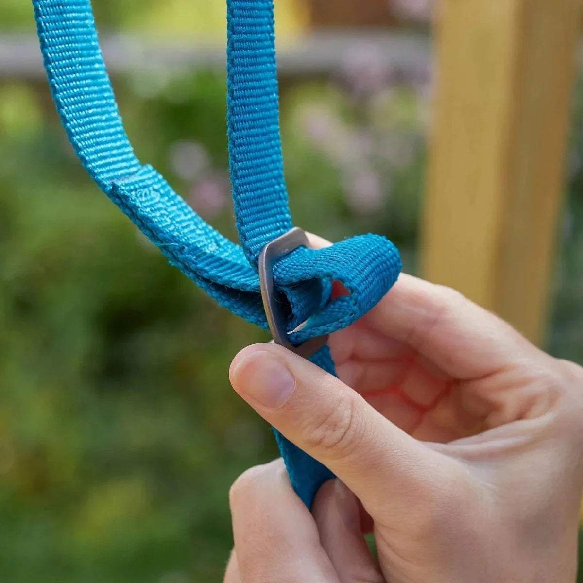 Blue swing strap loop held by a hand with metal clasp