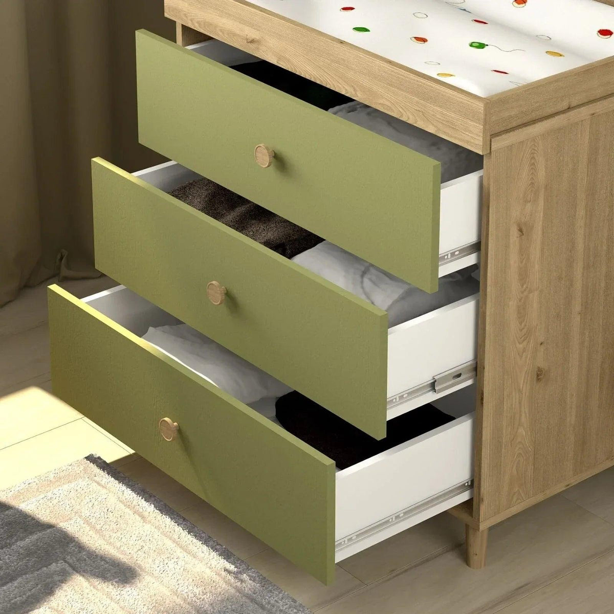 Pistachio green changing dresser with open drawer fronts and light wood base