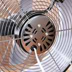 Close-up of white desk fan center hub inside the front safety grille