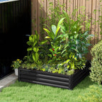 Raised garden bed with dark metal frame and mixed greenery in an outdoor yard