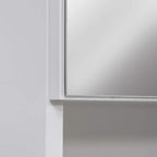 White bathroom mirror cabinet corner with framed mirrored door edge detail