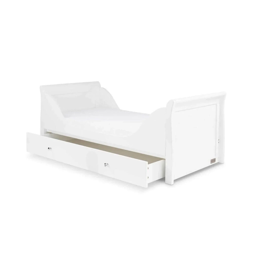 White toddler bed frame with panel sides and drawer front, side view