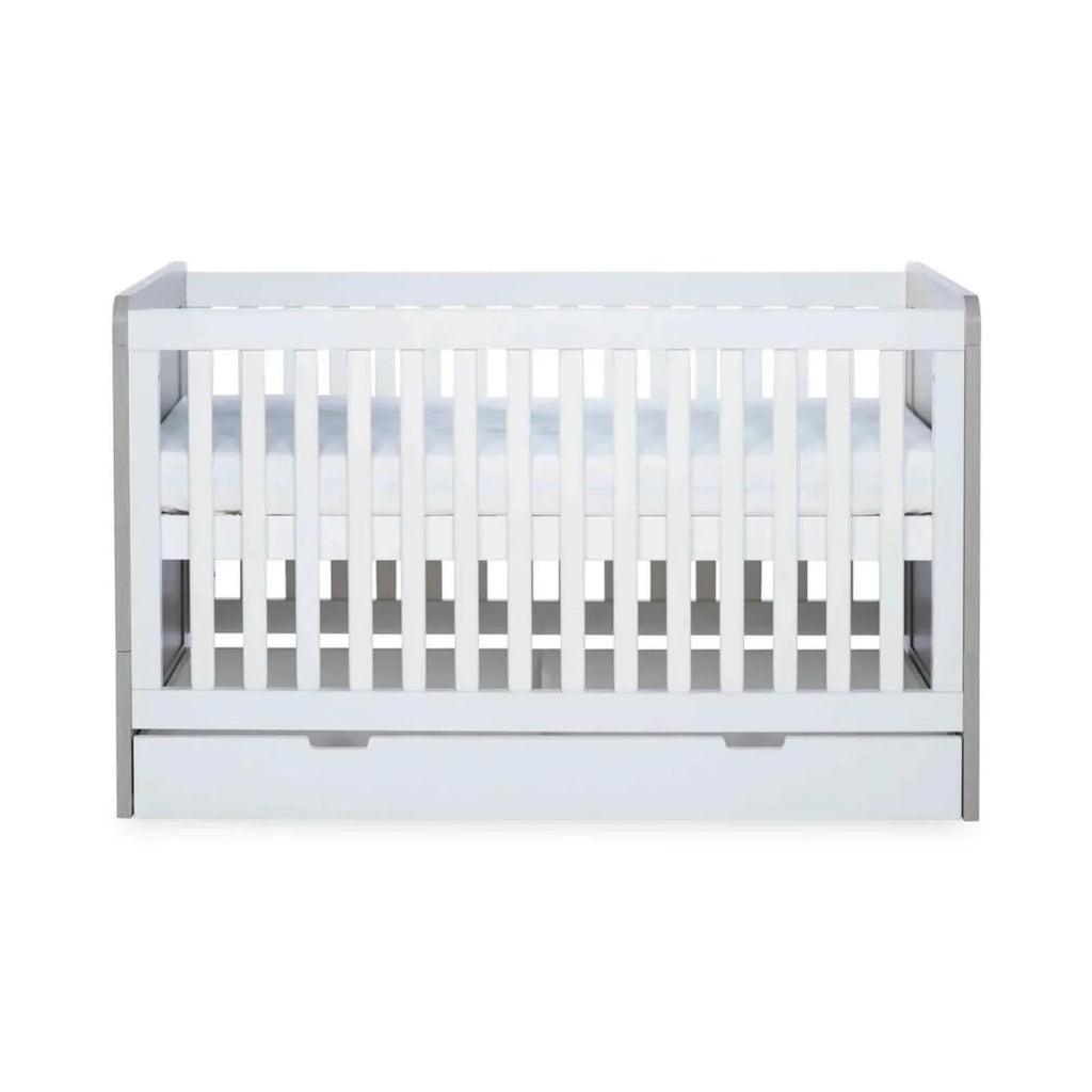 Grey-and-white baby cot interior with slatted safety sides