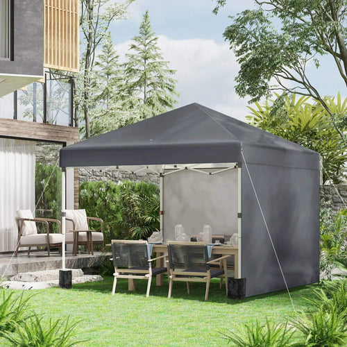 Dark grey pop-up gazebo tent with open side panels in a backyard setting
