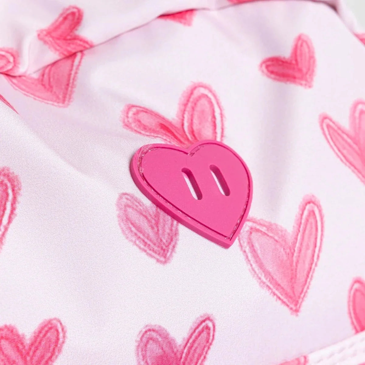 Pink heart print fabric detail with heart-shaped button
