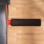 Close-up of black side padding on red-and-black adjustable weight bench