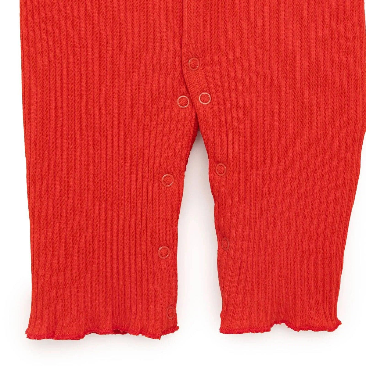 Orange rib-knit jumpsuit with snap buttons along the inseam