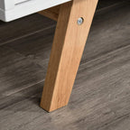 Wood TV stand leg with metal screw base under white cabinet