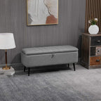 Grey upholstered flip-top storage bench with steel legs, rectangular ottoman