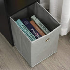 Gray fabric storage drawer with metal grommet handle inside the black desk