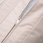 Beige sofa cushion close-up showing zipper seam and stitched fabric panels