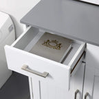 Single drawer of a white bathroom cabinet open, showing folded items inside
