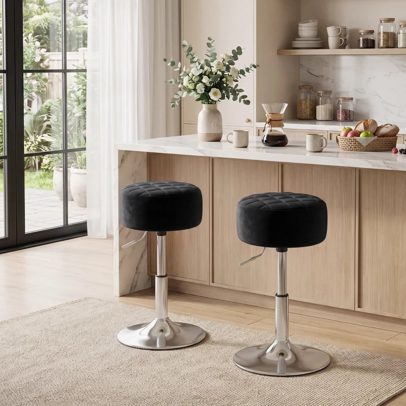 Two black round quilted bar stools with chrome pedestal bases