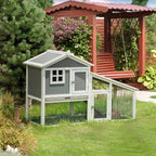 Grey two-tier rabbit hutch outdoors on grass, with wire run and hinged front door