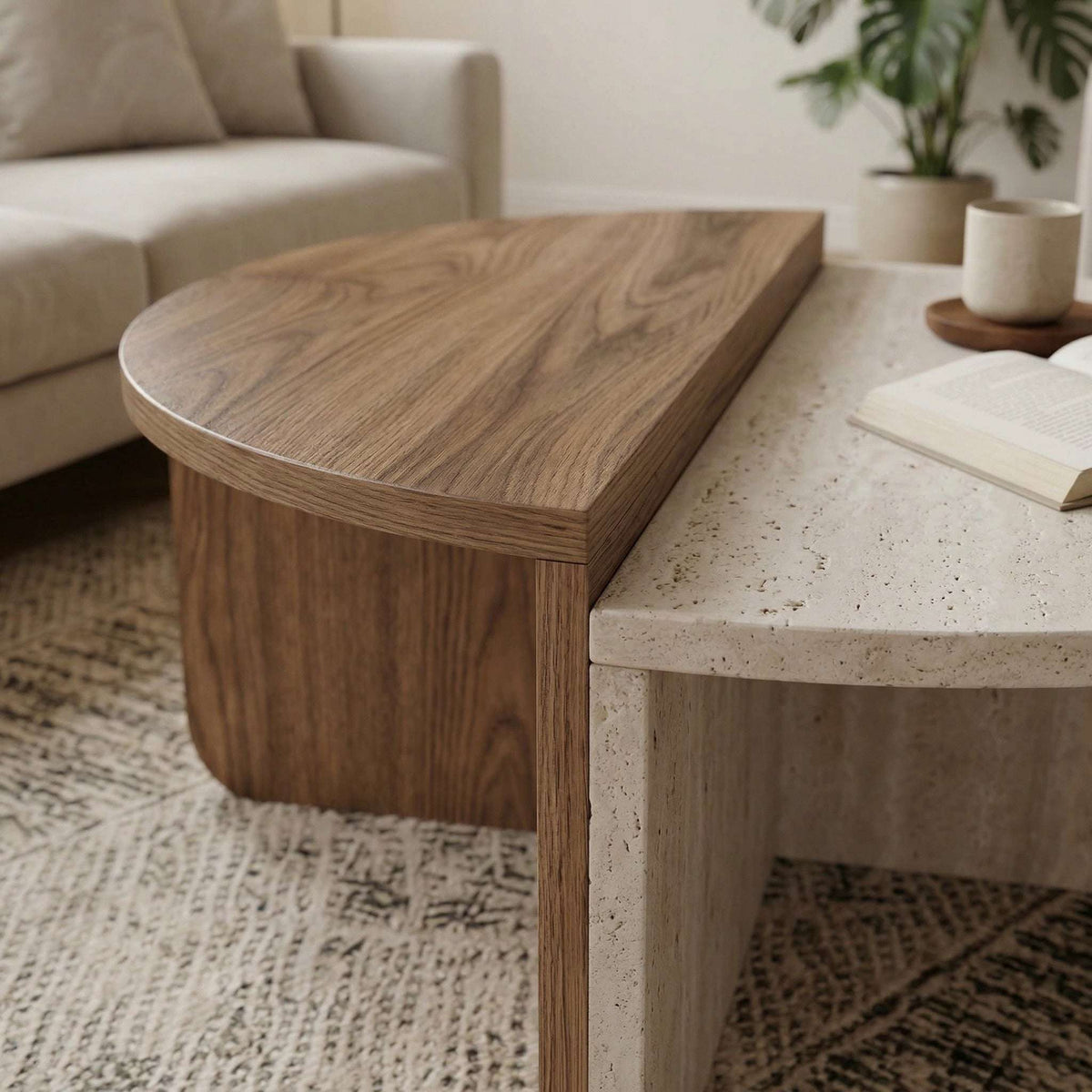 Modern round coffee table with light travertine top and dark wood base, rounded edges